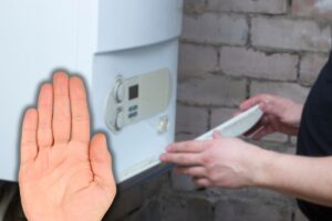 donna che apre sportello caldaia e mano che fa stop