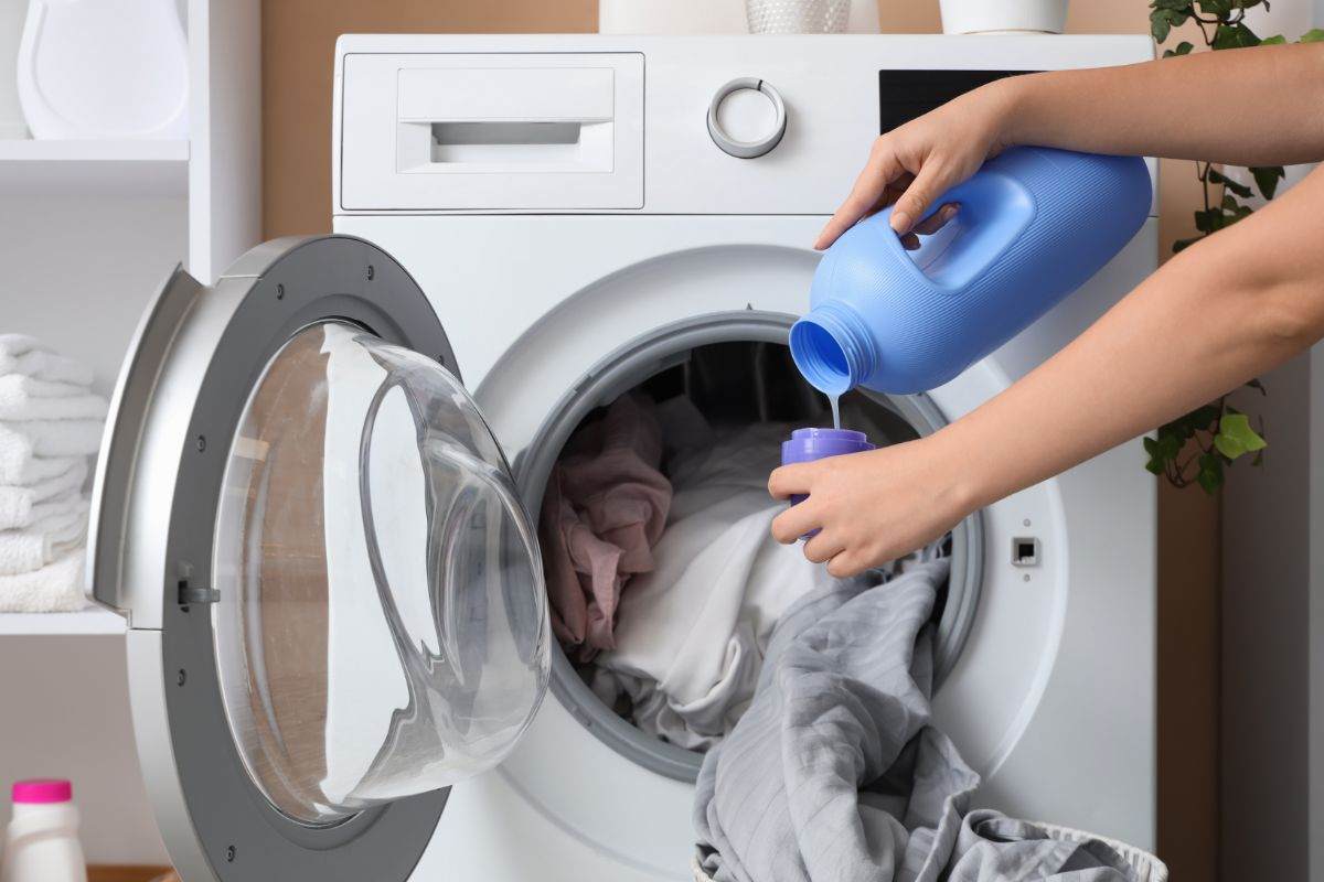 donna mette lenzuola in lavatrice
