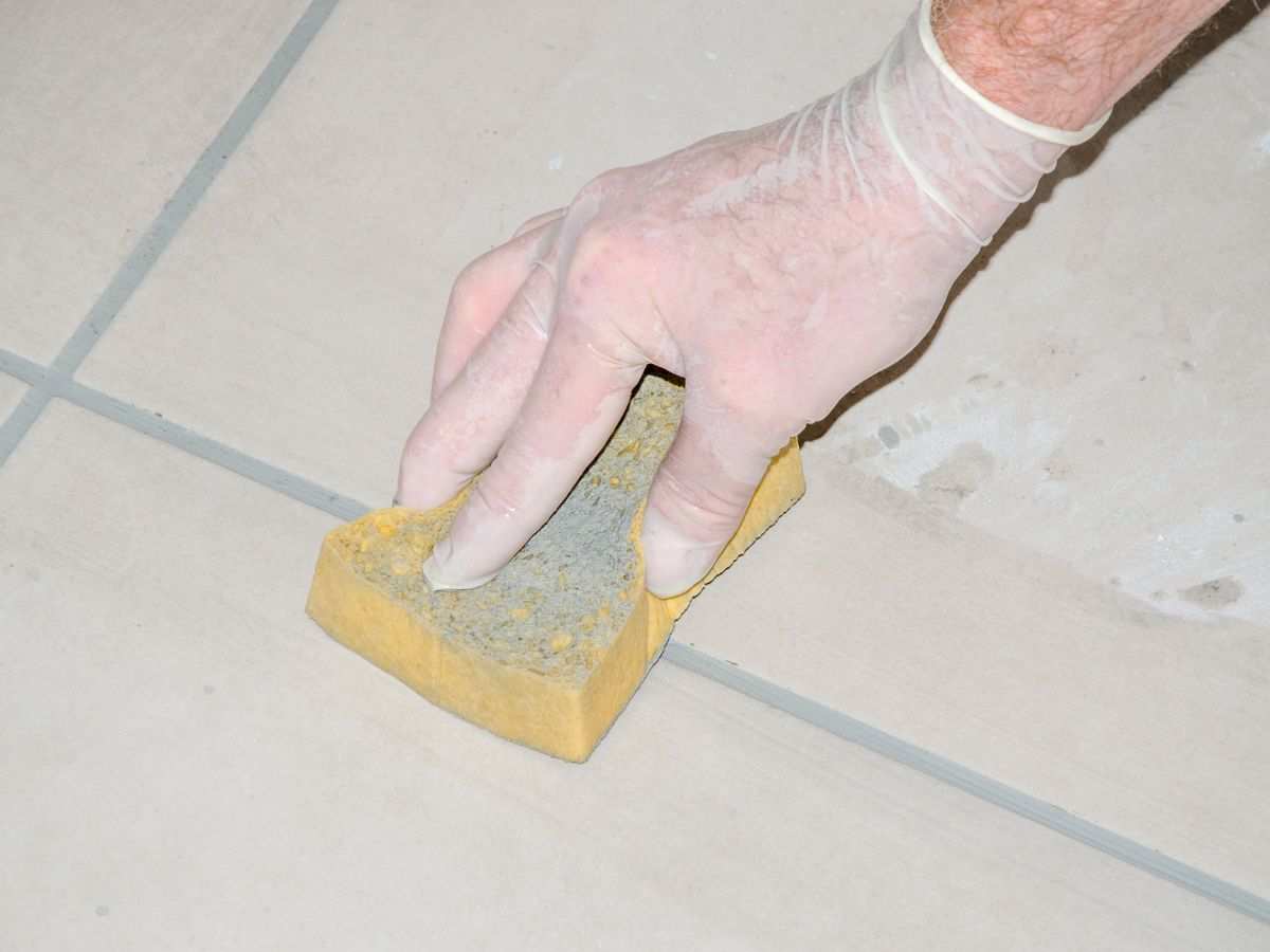 persona strofina spugnetta su fughe