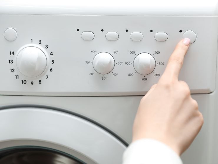 persona che imposta la lavatrice