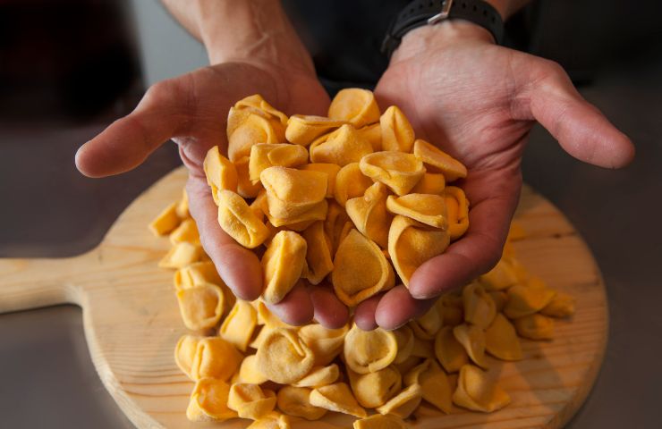 uomo che tiene in mano tortellini
